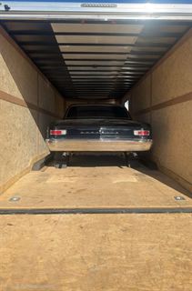 Classic car loaded inside the enclosed trailer — rear view showing space