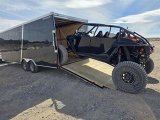 Enclosed trailer with ramp down loading a side-by-side UTV