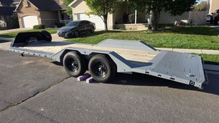 Rear three-quarter view of the equipment trailer with slide-out ramps